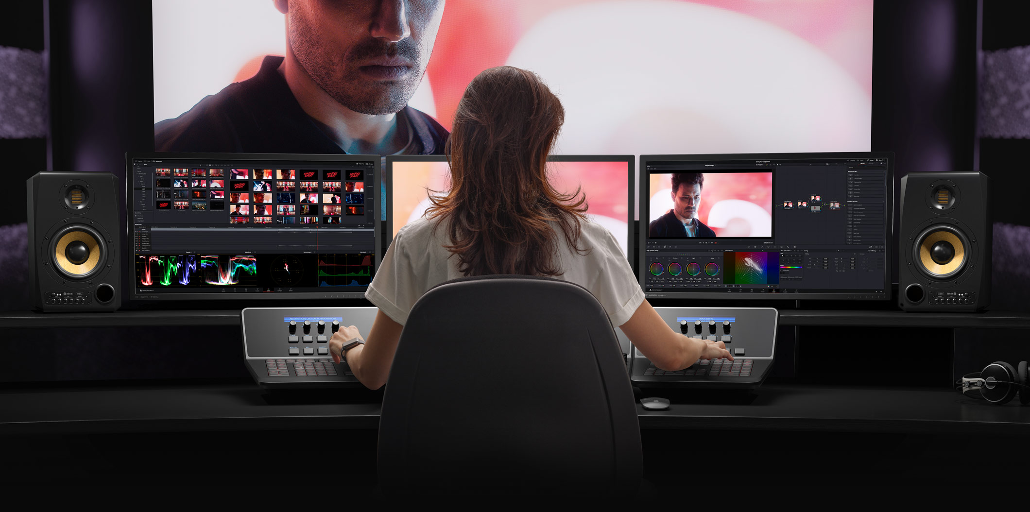 Colorista trabajando en un panel de control DaVinci Resolve frente a múltiples monitores